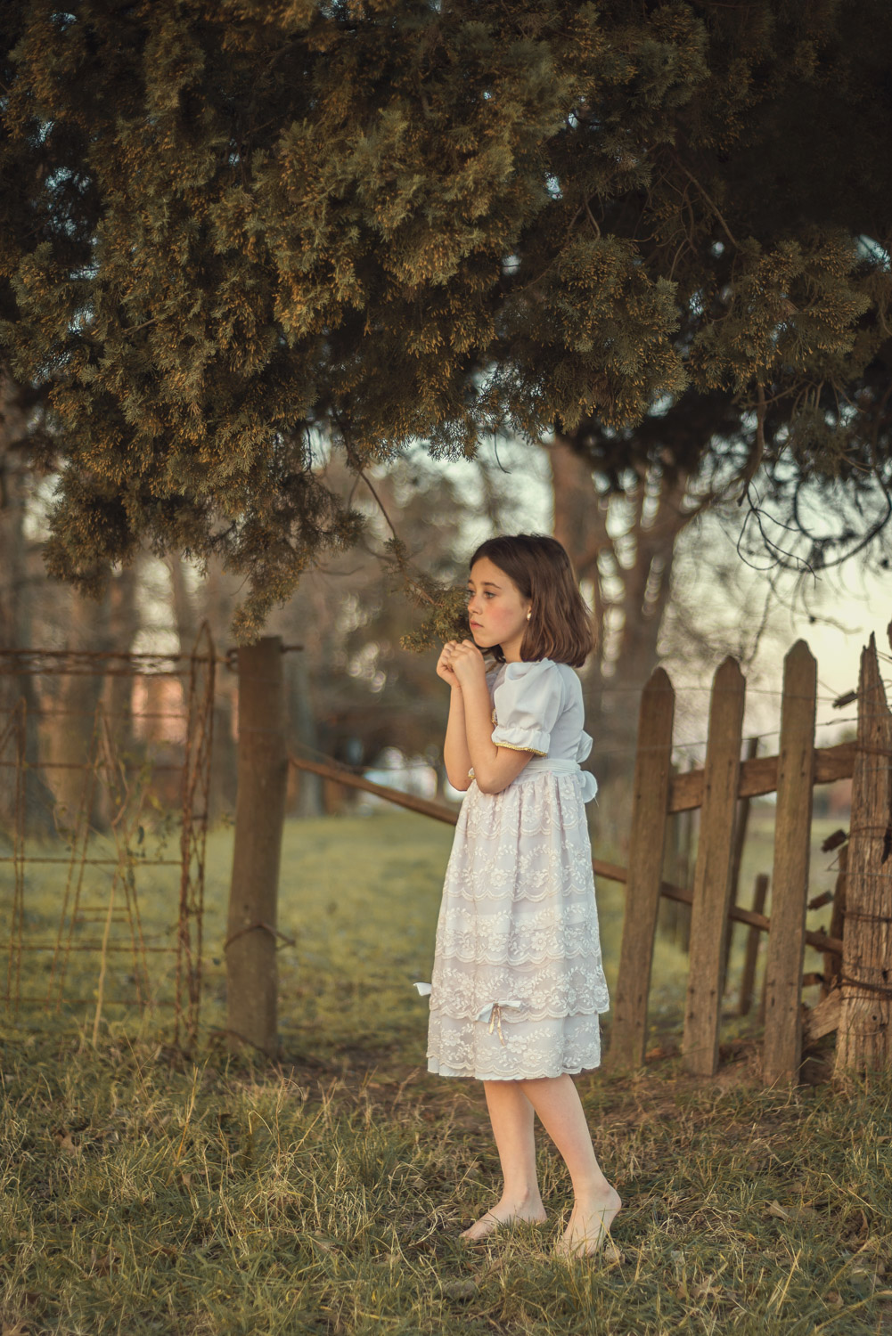 niña fotografiada en tranquera de campo